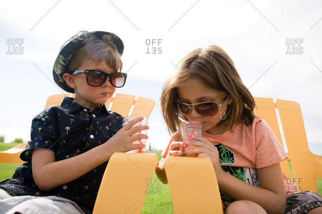 Children relaxing on yellow chairs with icy drinks