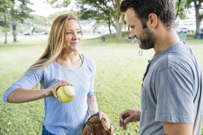 Woman holding softball by man