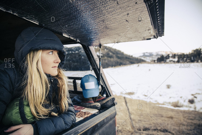 Woman looking out from the rear hatch of a pick up truck camper