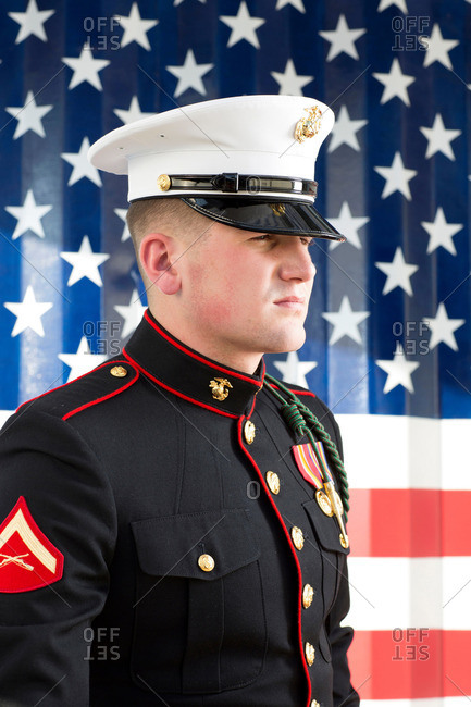Serviceman in dress blues by US flag