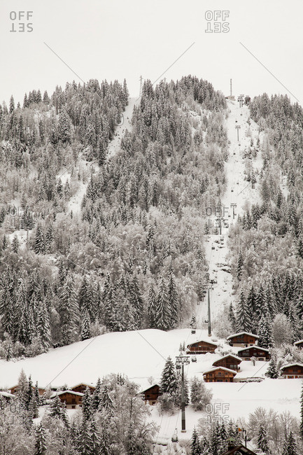 Chairlift over houses on snowy mountain
