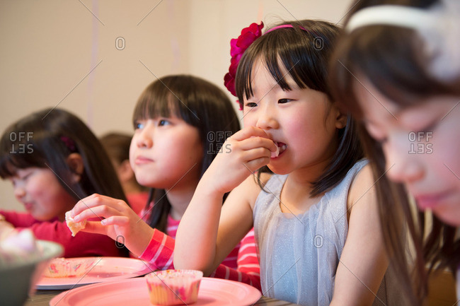 Girl\'s eating fairy cakes at party