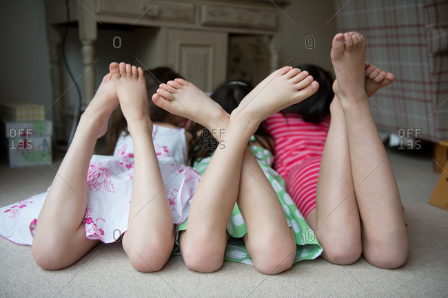 Girls lying on floor together with feet up