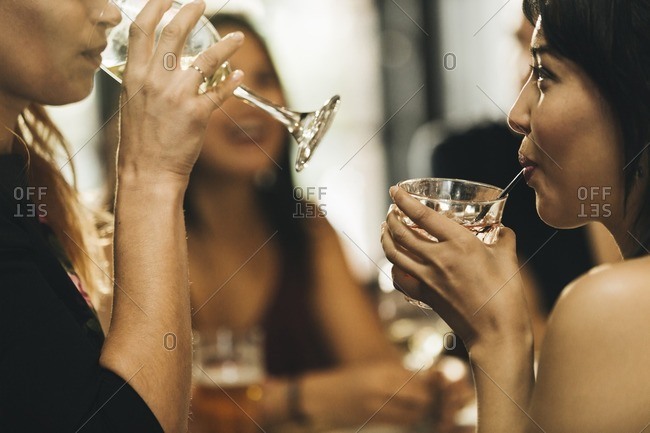 Close up of women having drinks in a bar