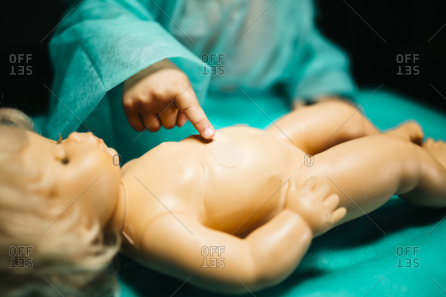 Young doctor healing a doll