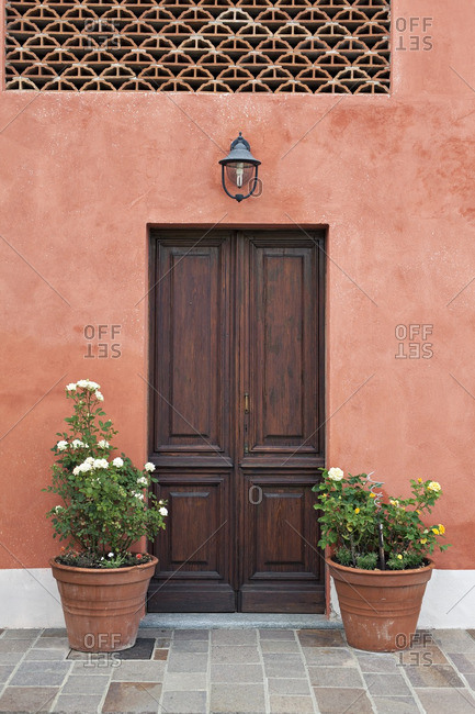 Wooden door on an orange building in Alba, Piedmont