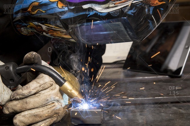 Person welding metal pieces