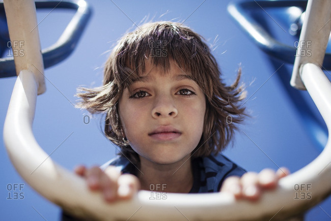 Boy leaning on outdoor play equipment at playground