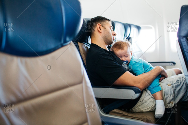 Dad and baby sleeping on plane