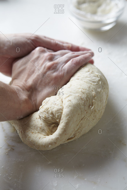 Person kneading dough on a table
