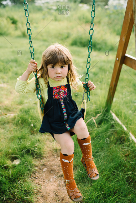 Little girl on a swing wearing socks and sandals