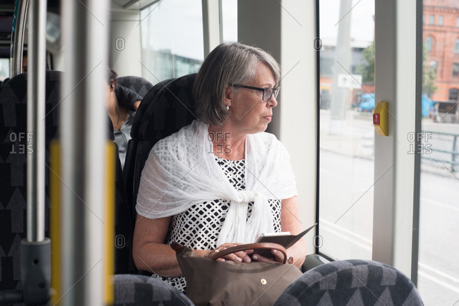Older woman riding on a bus looking out the window