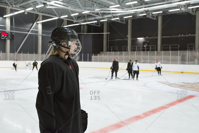 Sweden, Young hockey player wearing helmet standing on rink