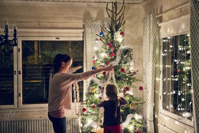 Finland, Mother with daughter decorating christmas tree