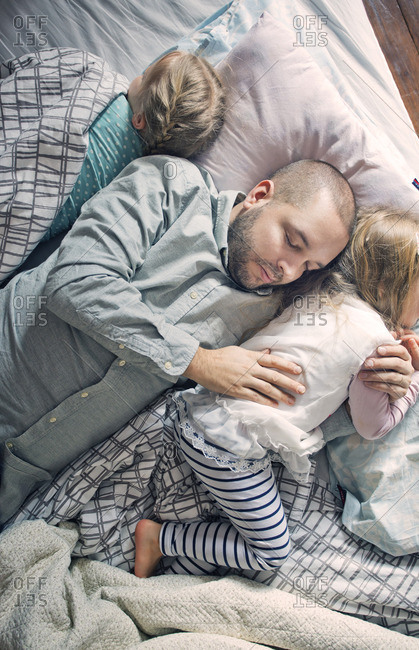 Finland, Father sleeping with daughters (12-17 months, 2-3) on bed