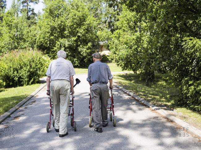 Finland, Esbo, Two senior men with walking frames walking away