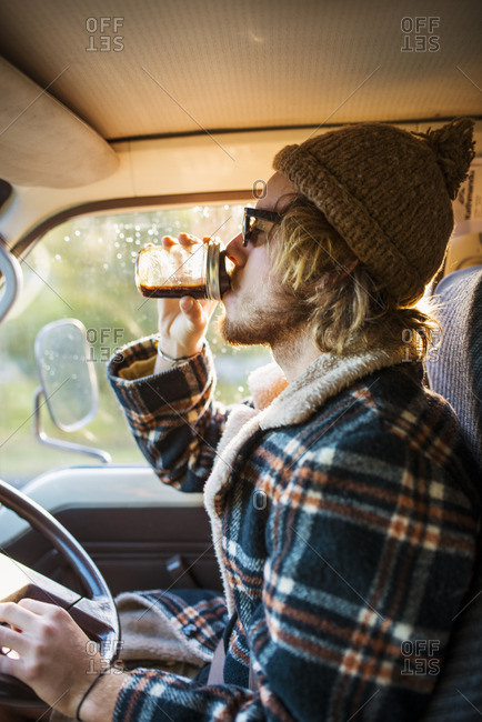 Australia, Queensland, Side view of driver drinking coffee in car