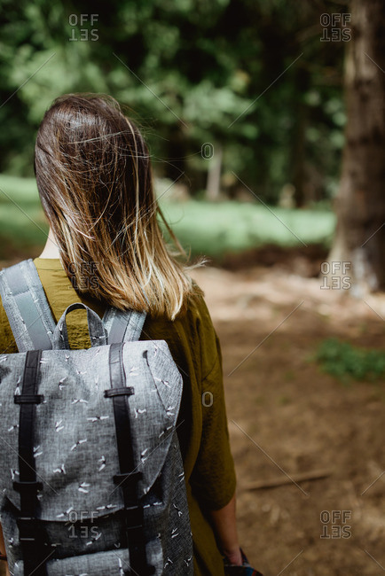 Woman walking in the forest wearing a backpack