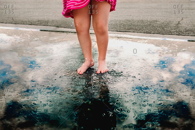 Feet of girl splashing in puddle