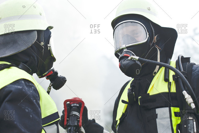 Two firefighters wearing oxygen masks
