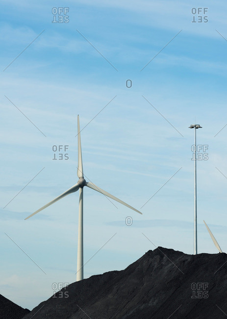Wind turbines in between piles of coal in Flushing harbor, Netherlands