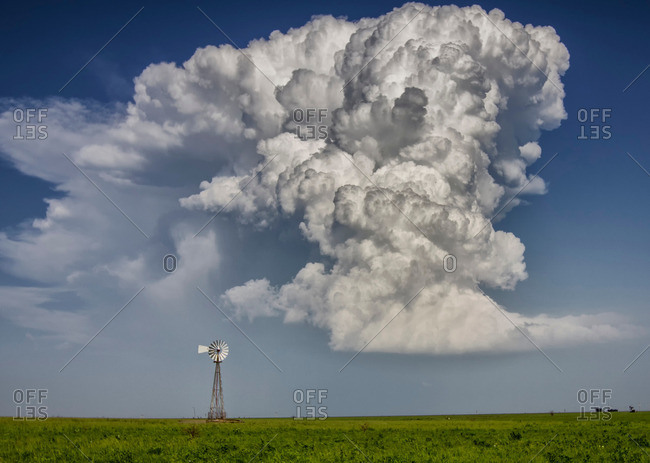Super cell cloud over windmill on fertile plain