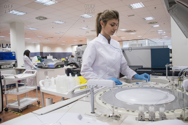 Laboratory technician in analytical laboratory using autoanalyzer