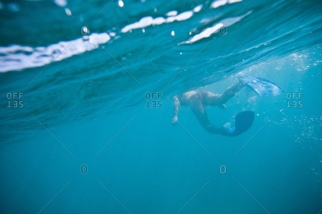 Woman in fins swimming in ocean