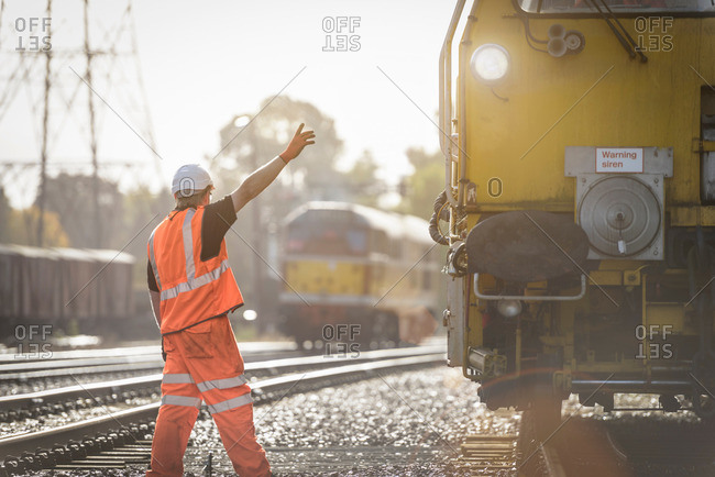 Maintenance worker signaling to train on railway