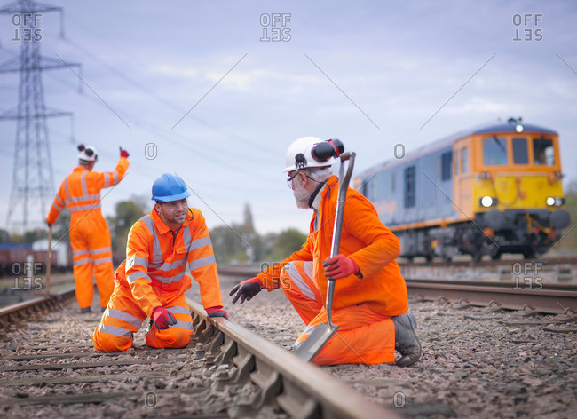 Apprentice railway worker instructed by engineer on railway