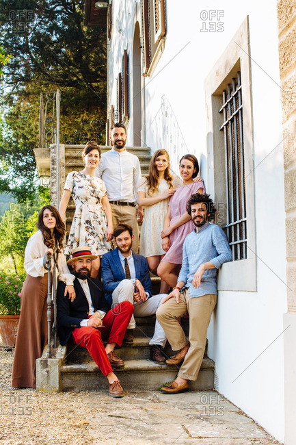 Portrait of group of friends, sitting on villa steps