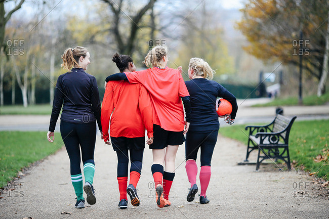 Rear view of female soccer players en route to play soccer in park