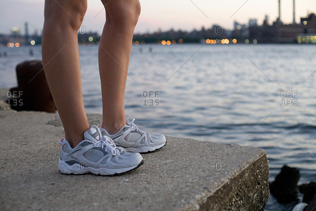 Legs and shoes of runner by river