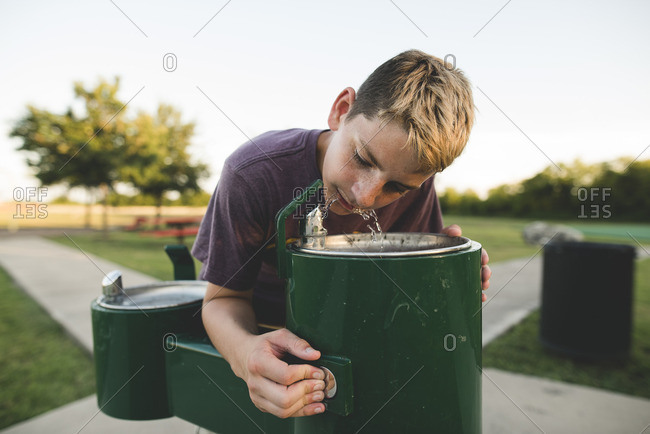Boy at park drinking fountain