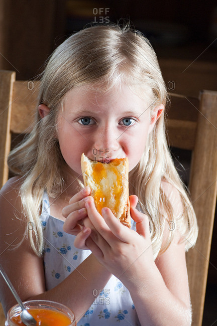 Girl eating bread with butter and jam