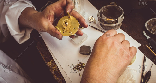 Hands of horologist repairing a watch in the workshop