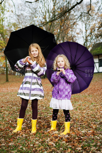 Girls in rain boots and umbrellas in a park