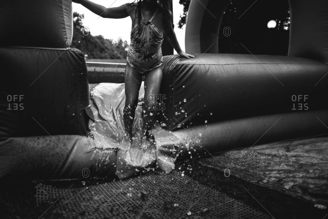Girl playing in the water in an inflatable bounce house