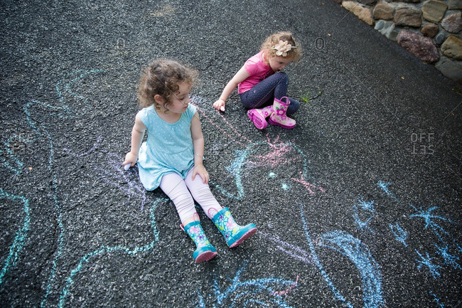 Girls drawing on pavement chalk
