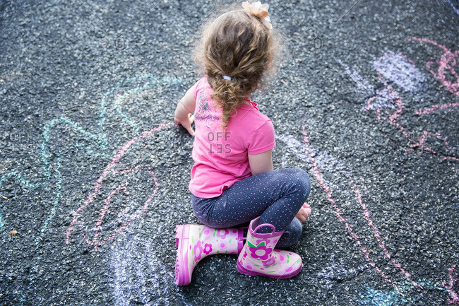 Girl drawing on pavement with chalk