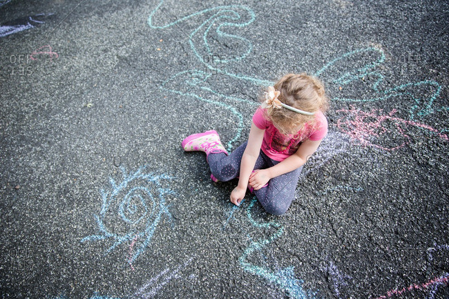 A girl chalk drawing on ground