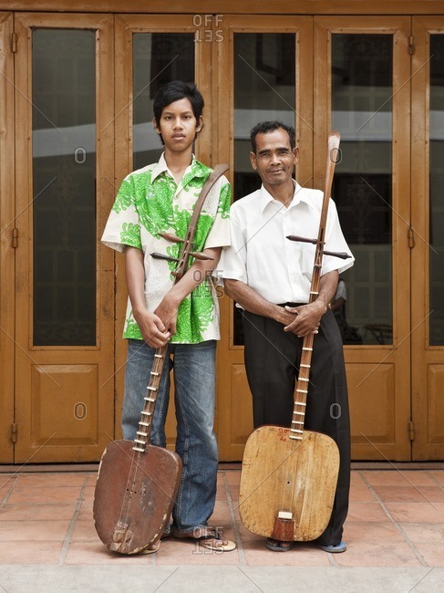 Teacher and student standing and holding traditional Cambodian lutes