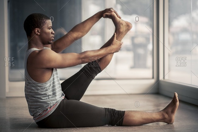 Male ballet dancer stretching his calves in a studio
