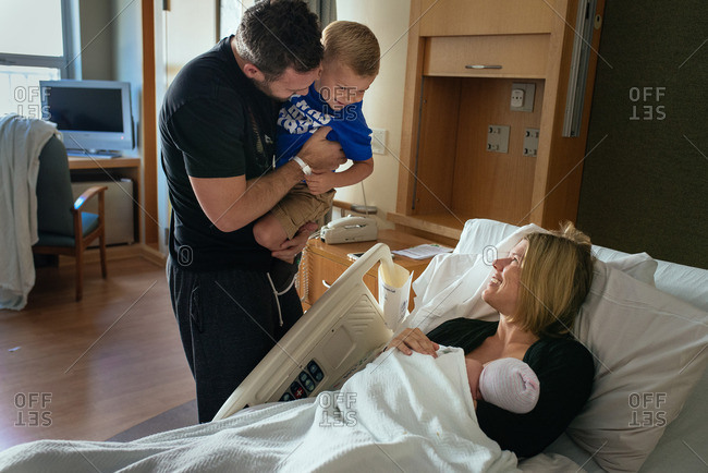 Family spending time together in a hospital room after the birth of their baby