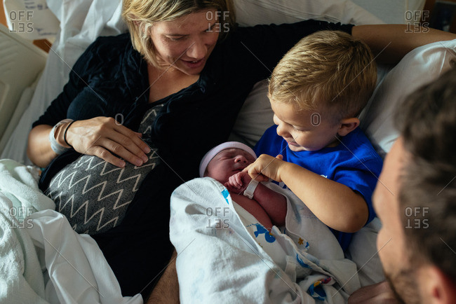 Close-up of a family spending time together in a hospital ward after the birth of their baby
