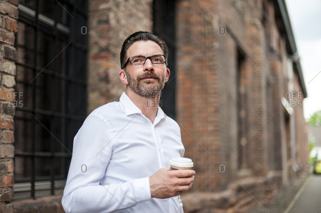 Businessman with coffee to go looking at distance
