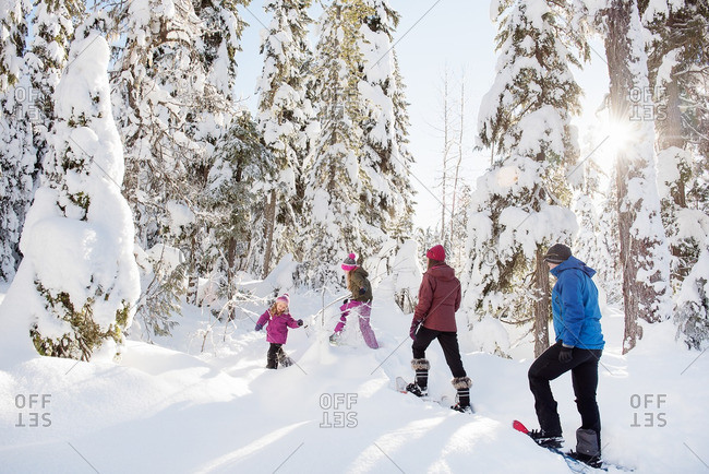 Family walking up snowy mountain