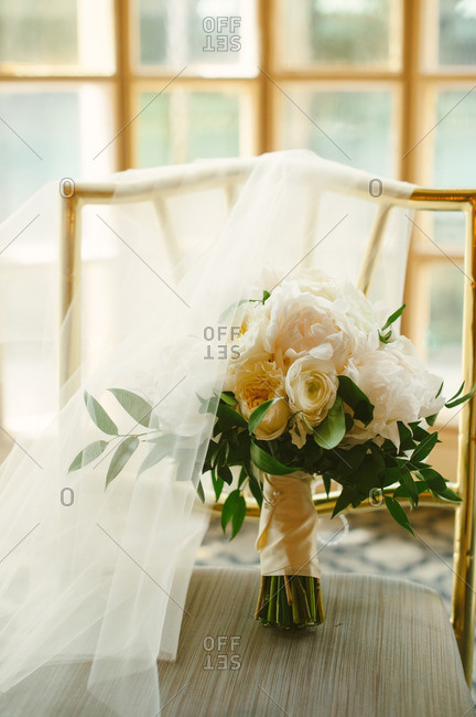 Wedding bouquet on chair with bridal veil