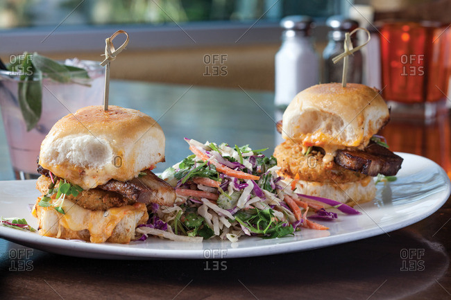 BLT sliders comprised of grilled pork belly, micro greens, fried green tomatoes, and house made pimiento cheese and slaw