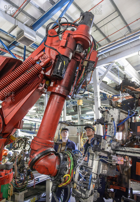 Apprentices inspecting robots in car plant